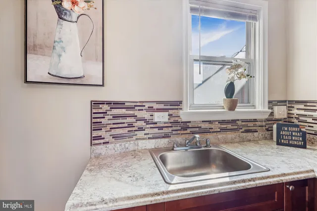 a kitchen with a sink and a stove with wooden floor