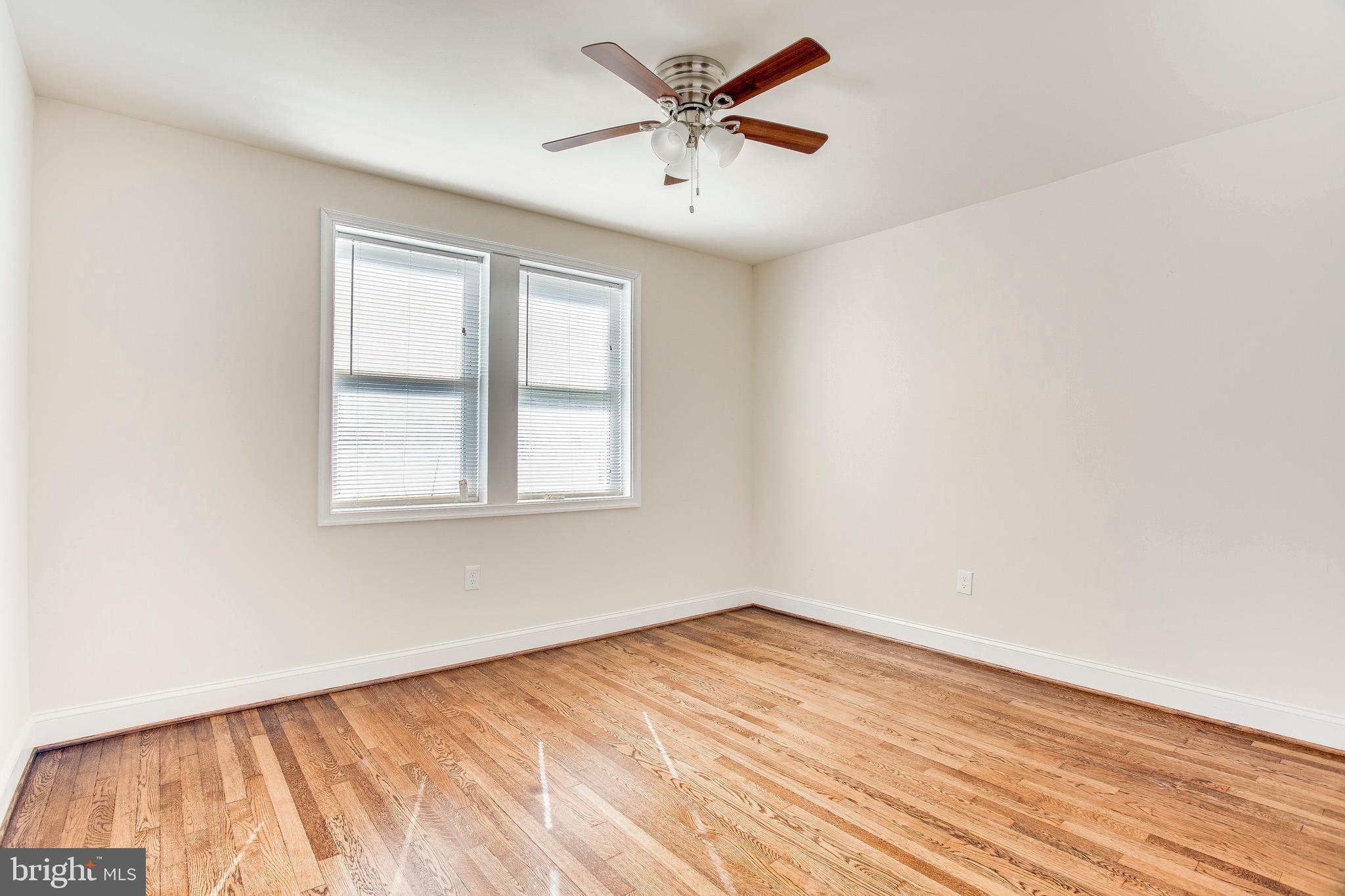 149 Denison Street, Unit 2 Baltimore, MD 21229 - Photo 14 of 19 an empty room with a window and a ceiling fan