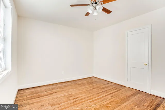 a view of a room with wooden floor and fan