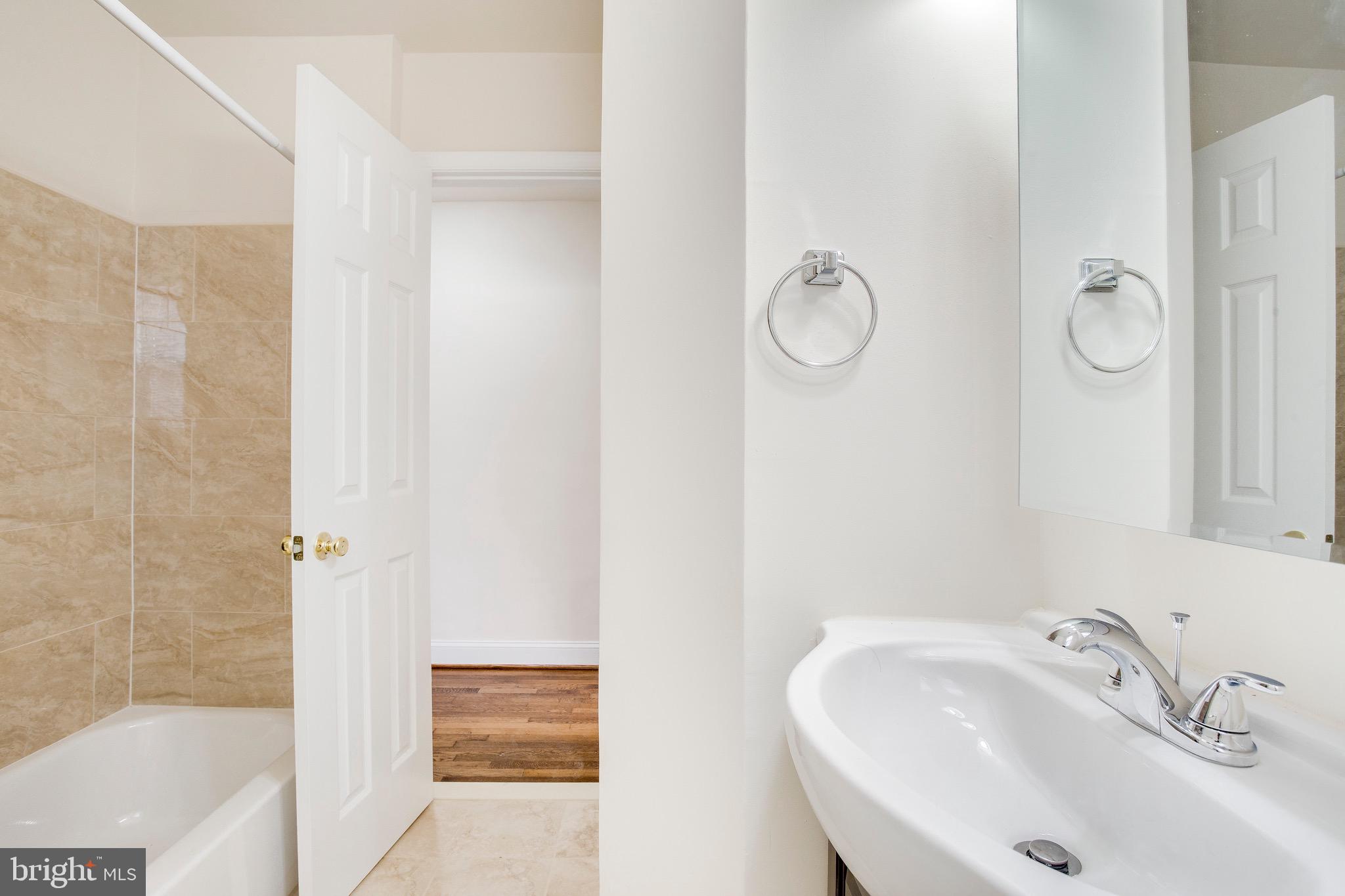 149 Denison Street, Unit 2 Baltimore, MD 21229 - Photo 16 of 24 a bathroom with a sink and a mirror
