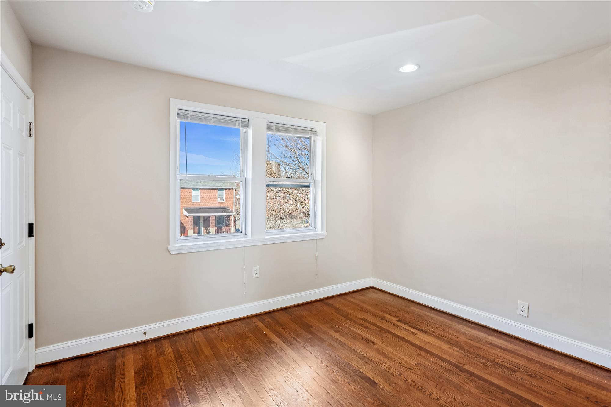 149 Denison Street, Unit 2 Baltimore, MD 21229 - Photo 5 of 24 a view of an empty room with wooden floor and a window