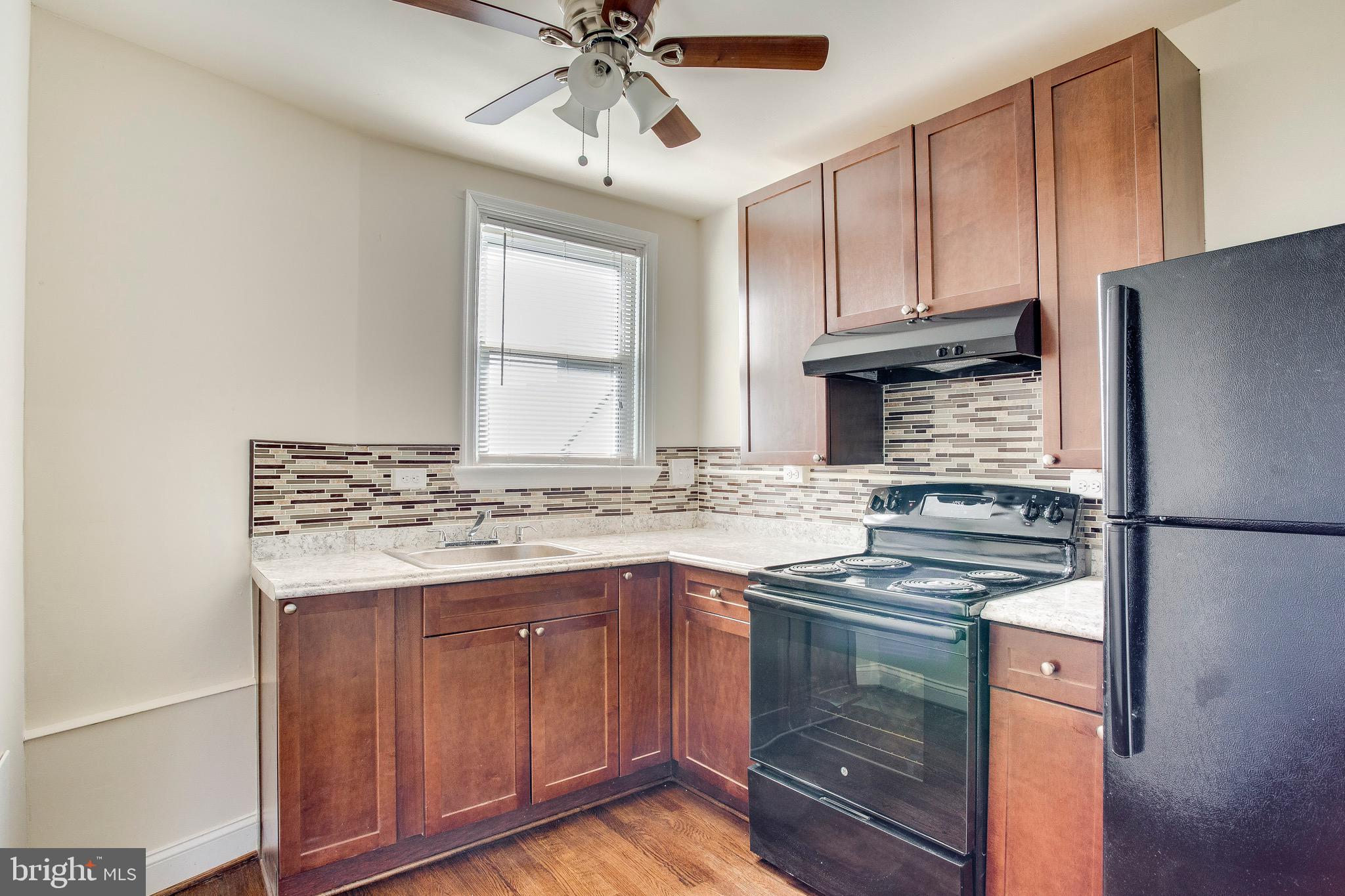 149 Denison Street, Unit 2 Baltimore, MD 21229 - Photo 9 of 19 a kitchen with stainless steel appliances granite countertop a stove and a refrigerator
