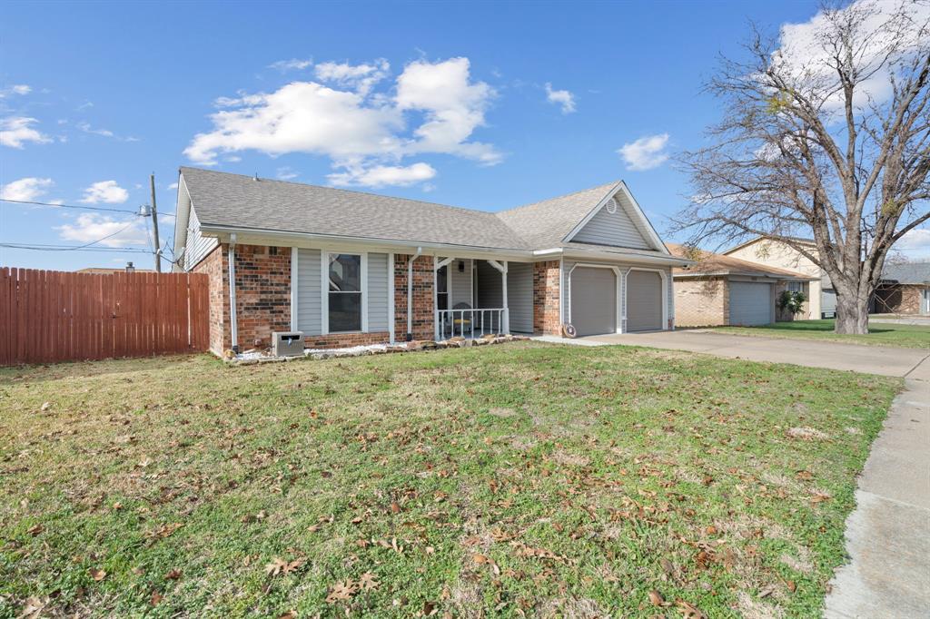 7629 Cedarhill Road Watauga, TX 76148 - Photo 2 of 33 Brick and siding exterior featuring a covered porch with white railing, a two-car garage with individual doors, and a partial wooden privacy fence