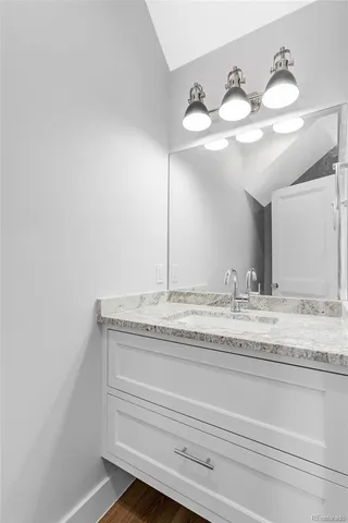 a bathroom with a granite countertop sink and a mirror