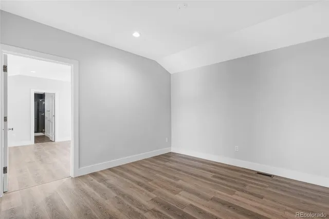 a view of an empty room with wooden floor