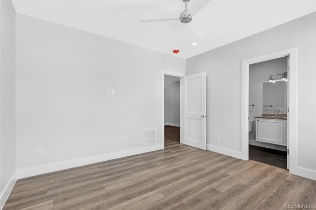 a view of a livingroom with wooden floor and a ceiling fan