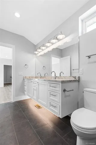 a spacious bathroom with a granite countertop sink mirror and toilet