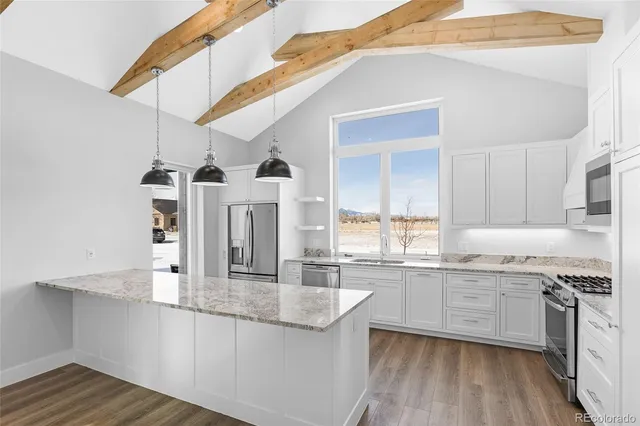 a kitchen with granite countertop a sink cabinets and wooden floor