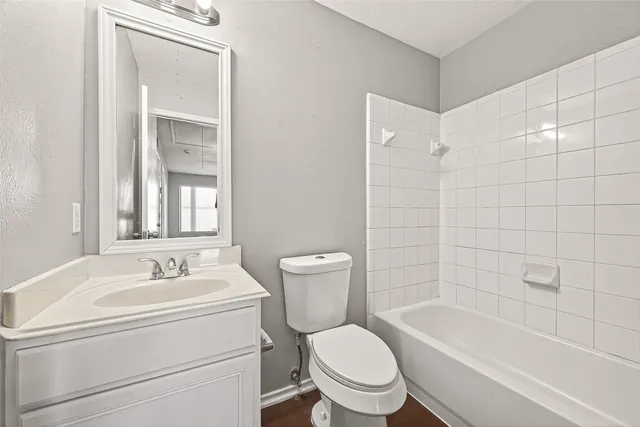 a bathroom with a double vanity sink a toilet a bathtub and shower