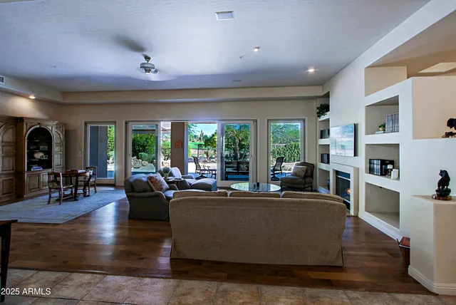 a living room with furniture fireplace and a large window