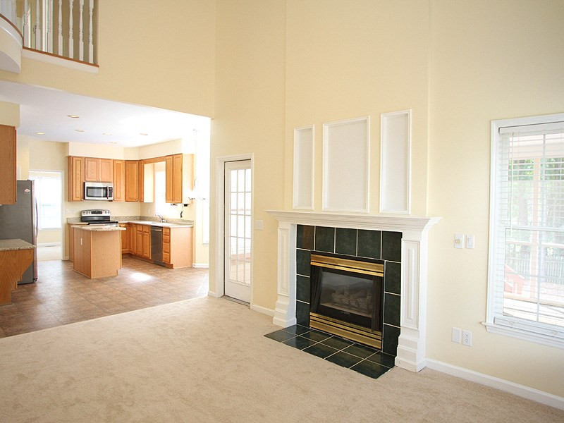 2305 Kendricks Court Raleigh, NC 27613 - Photo 8 of 23 2nd floor balcony overlooks FR with soaring 2-story ceiling, gas log fireplace with tile surround, ceiling fan, and French door to screened porch. Den/Family/Great Room