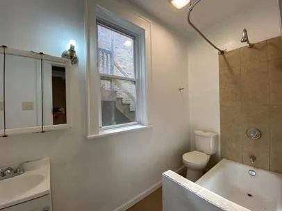 a bathroom with a tub sink and mirror