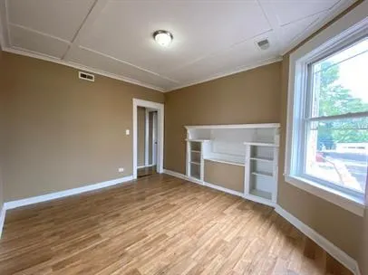 a view of empty room with wooden floor and fireplace