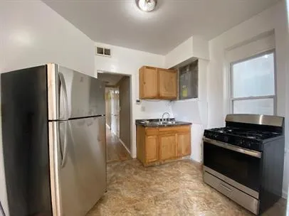 a kitchen with stainless steel appliances granite countertop a refrigerator a stove a sink dishwasher and a refrigerator