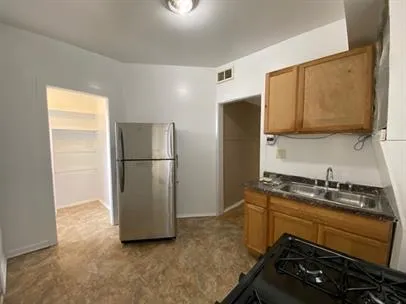 a kitchen with a refrigerator and a sink