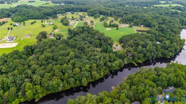 an aerial view of a house with a yard and lake view