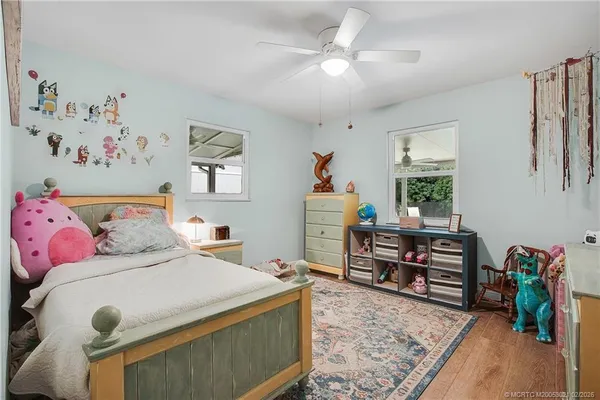 a bedroom with a bed and a wooden floor