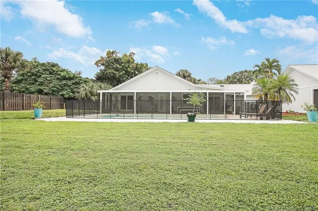 a view of a house with a swimming pool and a yard