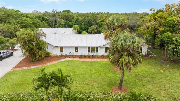 a view of a house with a backyard and a tree
