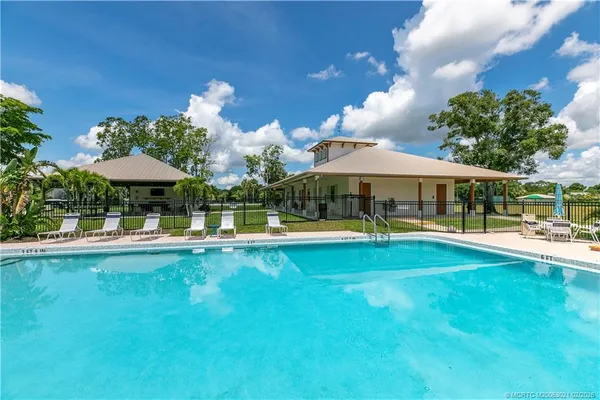 a view of a swimming pool with lawn chairs under an umbrella