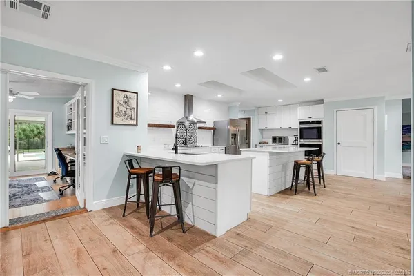 a kitchen with white cabinets and chairs