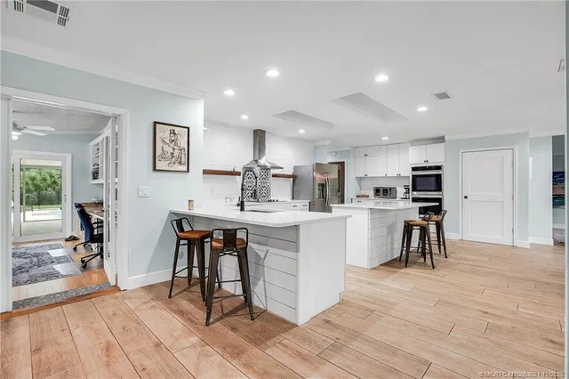 a kitchen with white cabinets and chairs