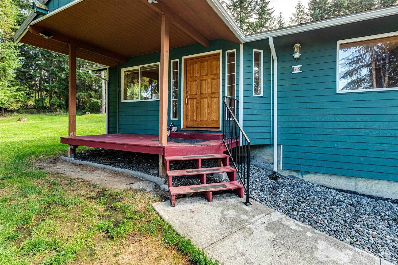 73 Ross Lane Port Angeles, WA 98363 - Photo 3 of 40 a view of a backyard with a small deck and a yard