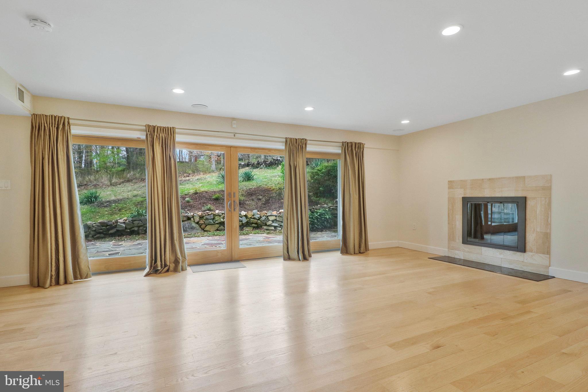 8543 Howell Road Bethesda, MD 20817 - Photo 11 of 24 a view of an empty room with a fireplace and a window