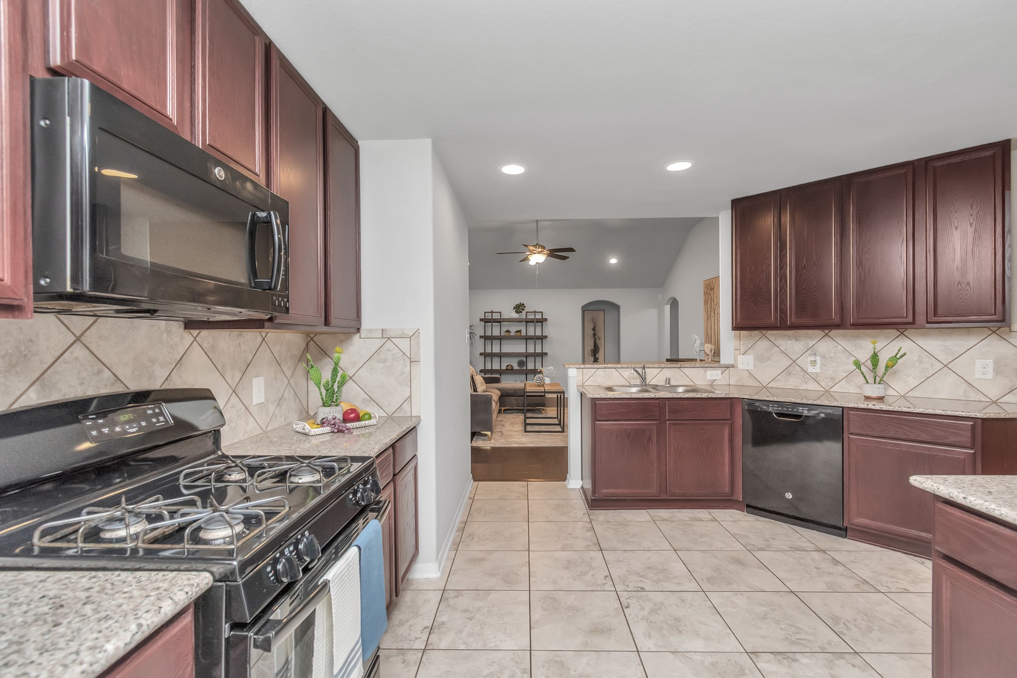 2411 Zephyr Lane Rosenberg, TX 77471 - Photo 10 of 20 a kitchen with stainless steel appliances granite countertop a stove top oven microwave and cabinets