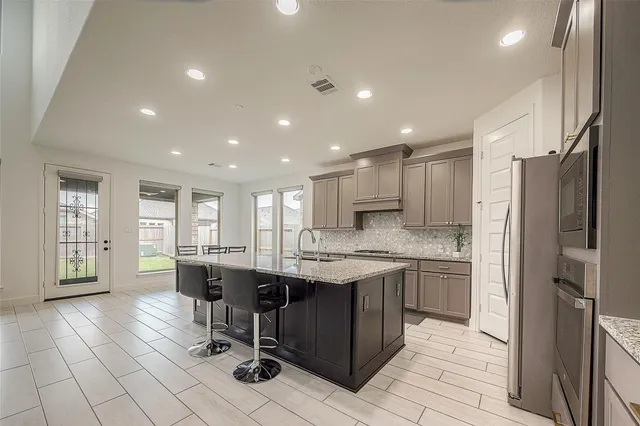 a kitchen with stainless steel appliances kitchen island granite countertop a sink and cabinets
