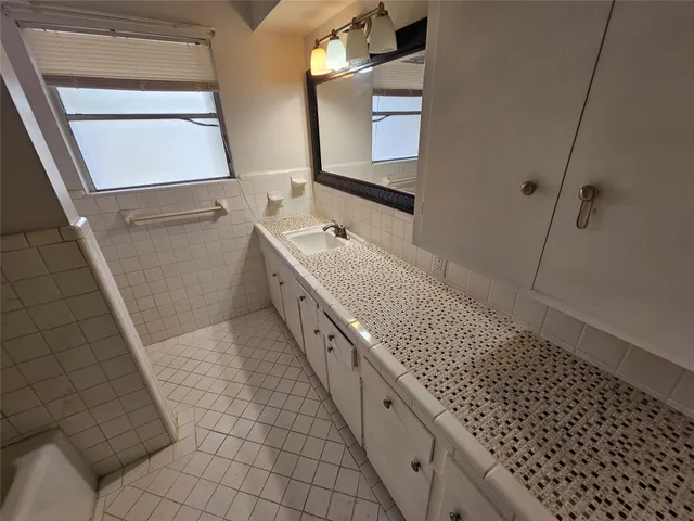 a bathroom with a double vanity sink a toilet and mirror