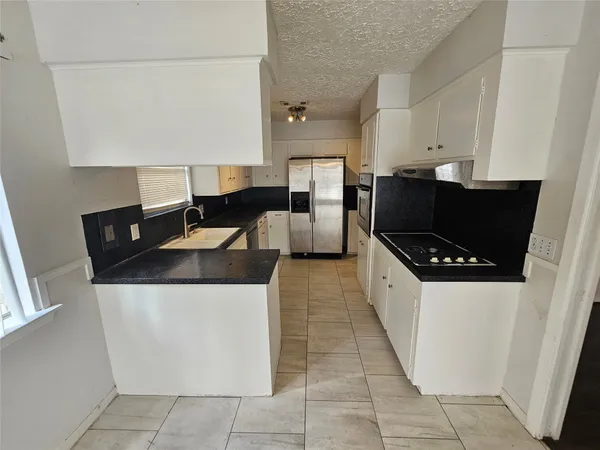a kitchen with a sink a counter top space and cabinets