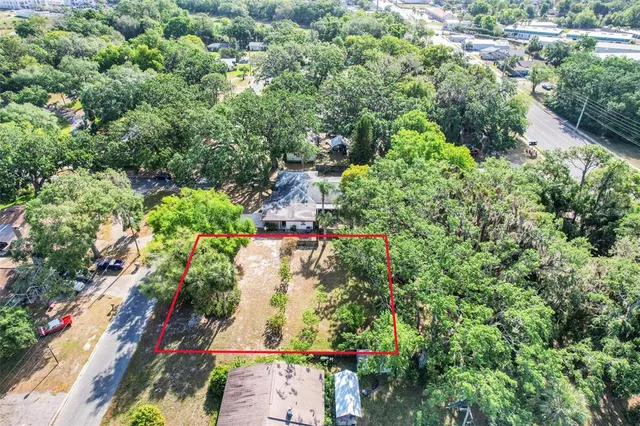 an aerial view of residential houses with outdoor space and trees all around