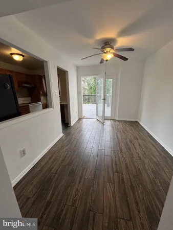 a view of a livingroom with wooden floor and a ceiling fan