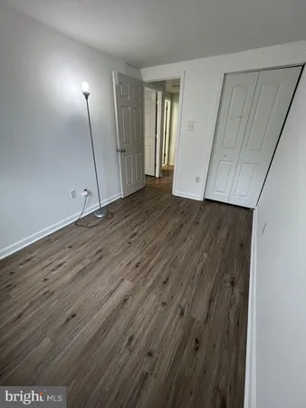 an empty room with wooden floor and mirror