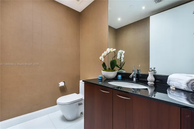 a bathroom with a granite countertop sink and a toilet