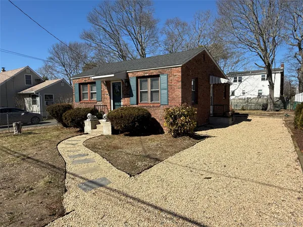 a front view of a house with a yard and seating space