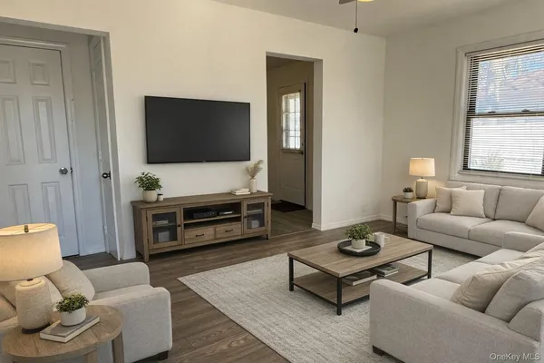 a living room with furniture a flat screen tv and a window