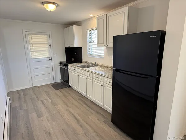 a kitchen with a refrigerator and a stove top oven