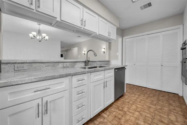 a kitchen with granite countertop white cabinets and stainless steel appliances
