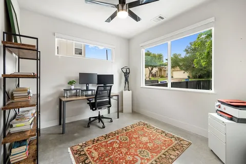 a view of a workspace with furniture and a window