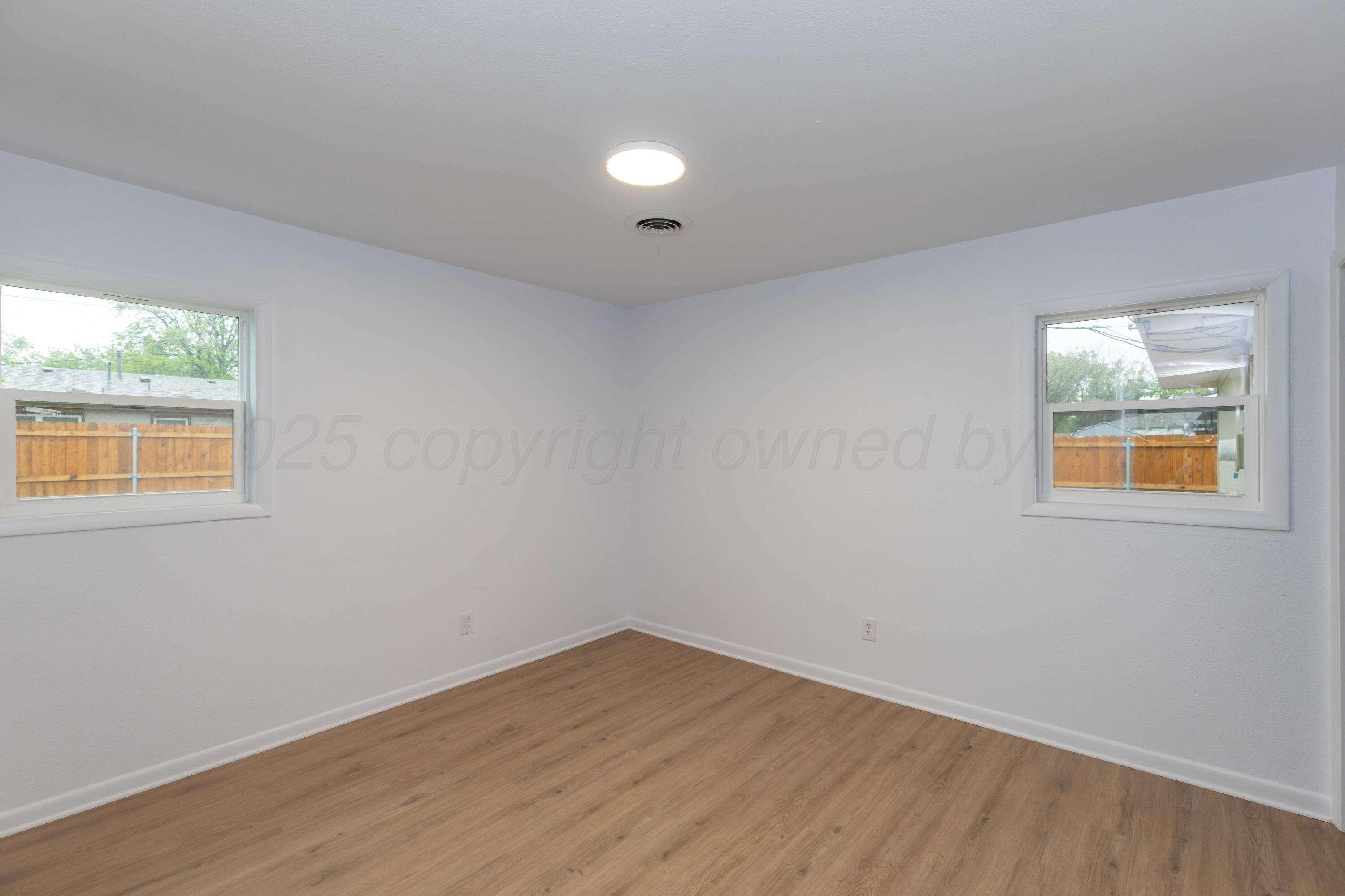 4708 South Lamar Street Amarillo, TX 79110 - Photo 20 of 40 a view of an empty room with wooden floor and a window