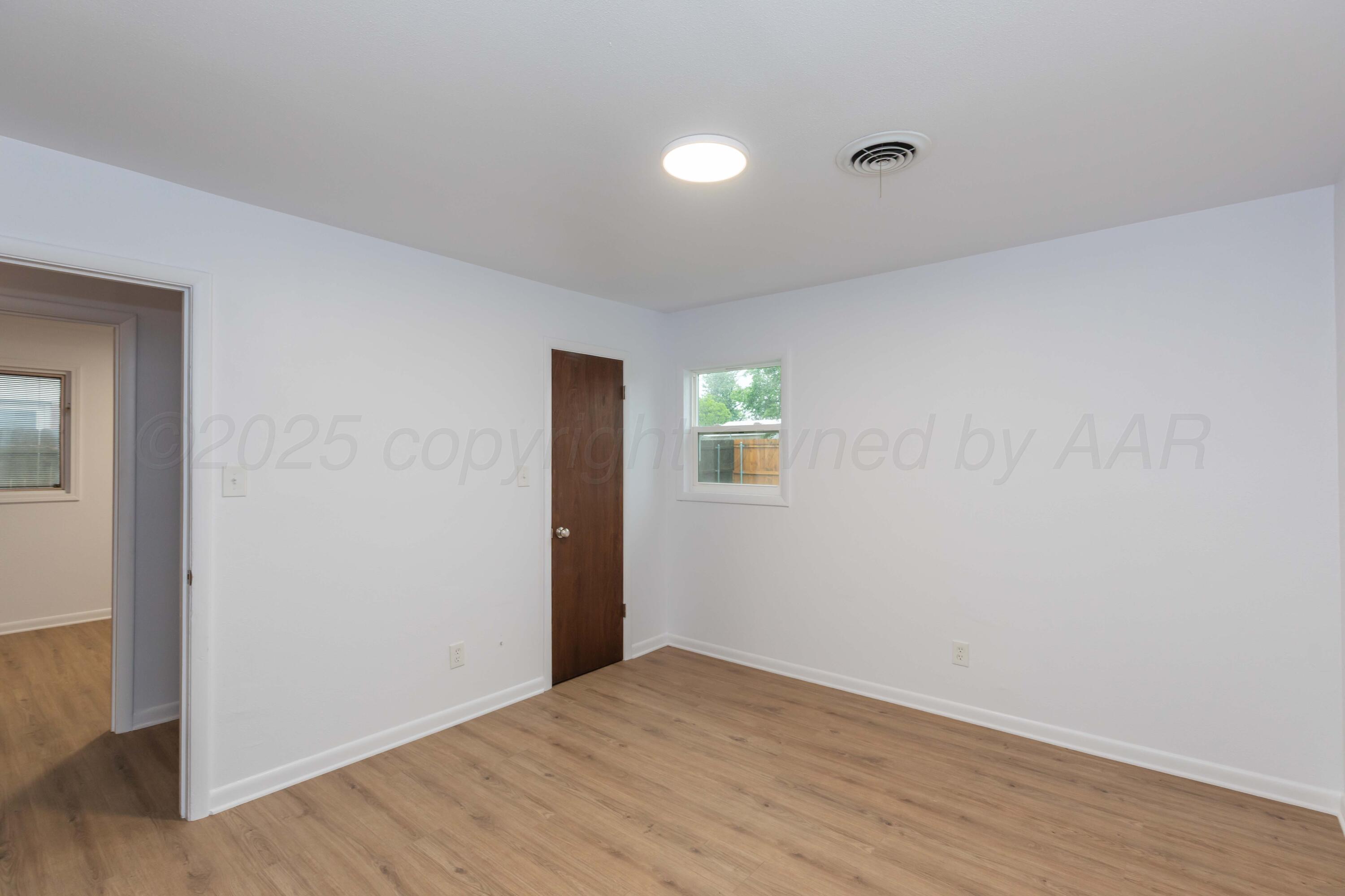 4708 South Lamar Street Amarillo, TX 79110 - Photo 21 of 40 a view of an empty room with wooden floor and a window