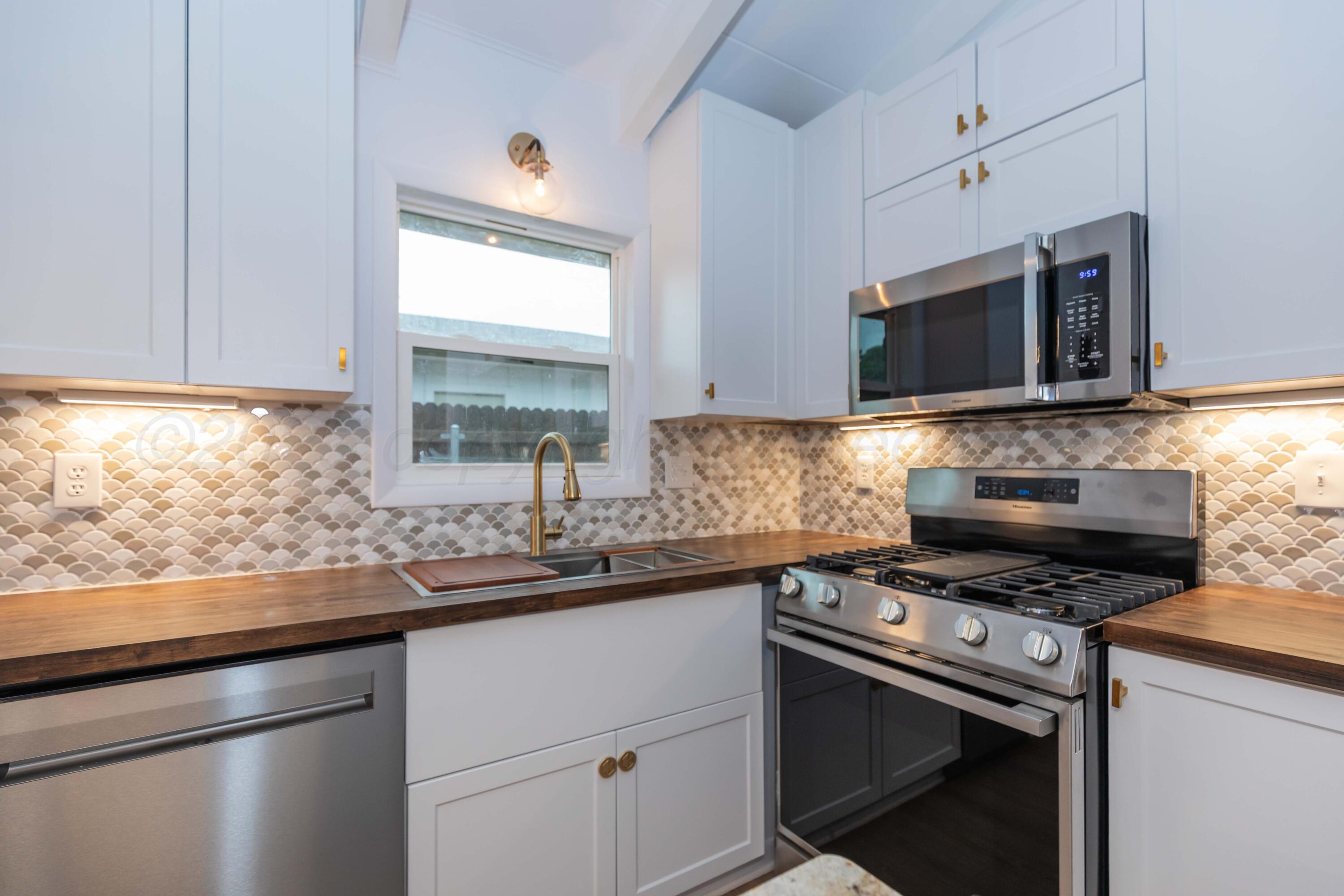 4708 South Lamar Street Amarillo, TX 79110 - Photo 4 of 40 a kitchen with stainless steel appliances a sink stove and microwave