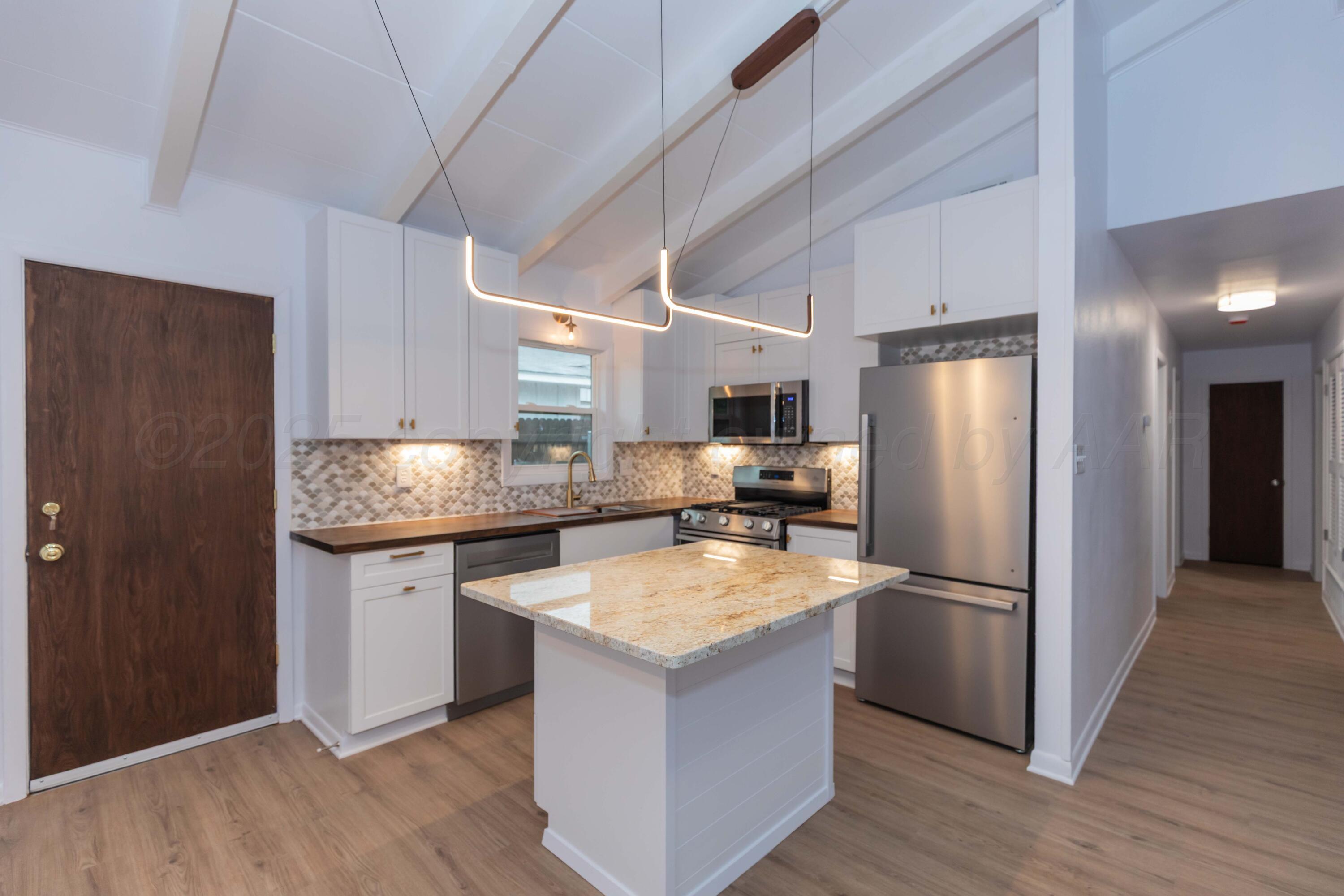 4708 South Lamar Street Amarillo, TX 79110 - Photo 7 of 40 a kitchen with granite countertop a refrigerator and a sink