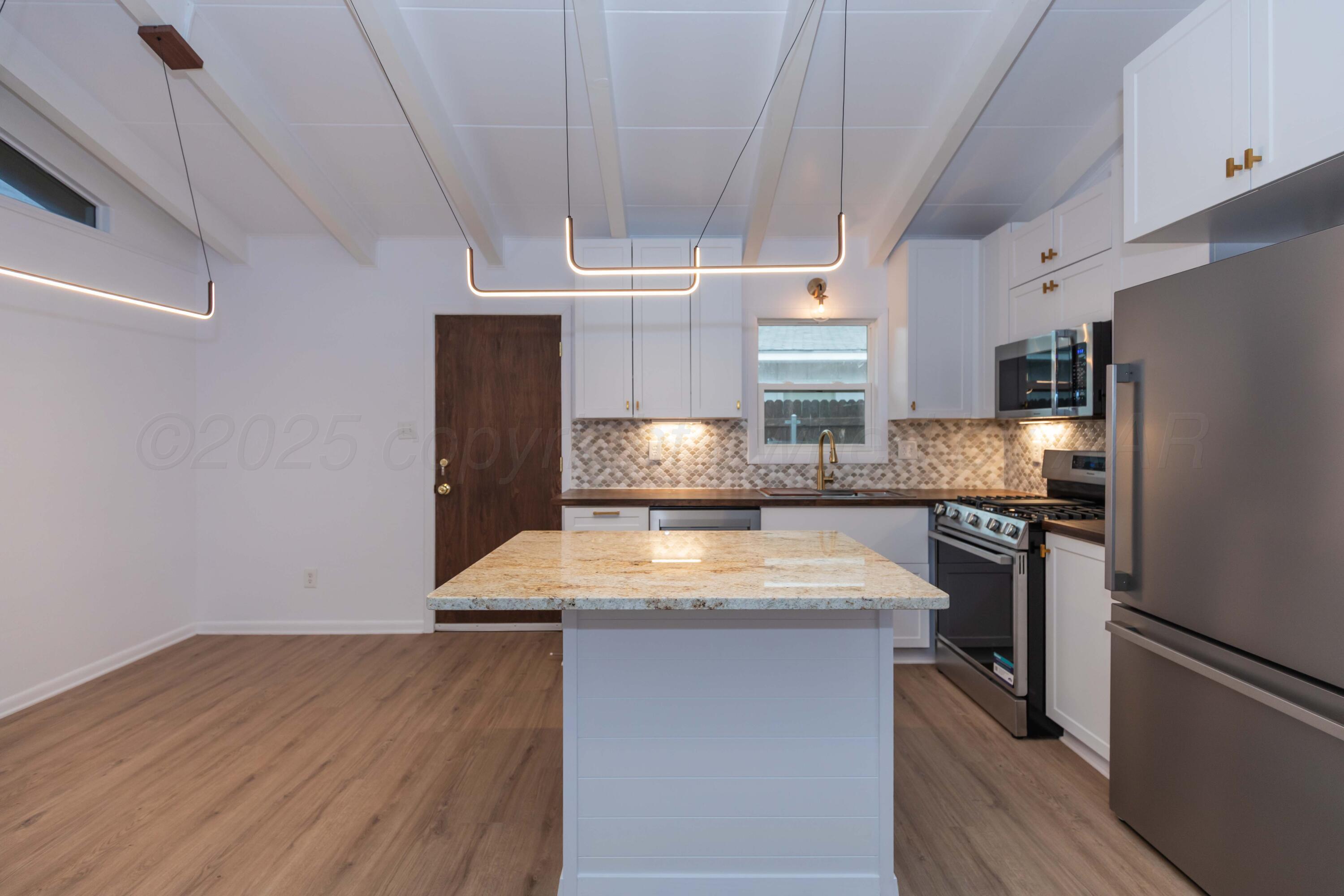 4708 South Lamar Street Amarillo, TX 79110 - Photo 8 of 40 a kitchen with a wooden floor and a stove top oven