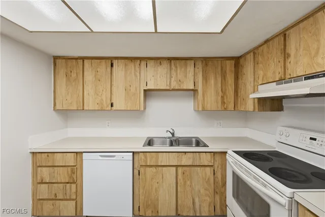 a kitchen with a sink a stove and cabinets