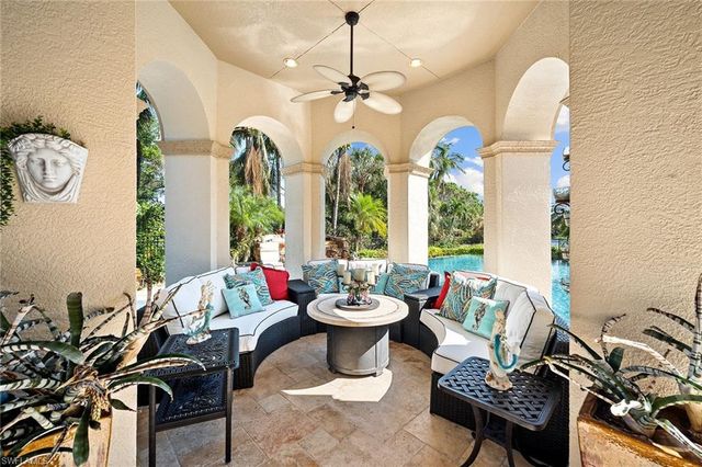 a living room with furniture a chandelier and a large window