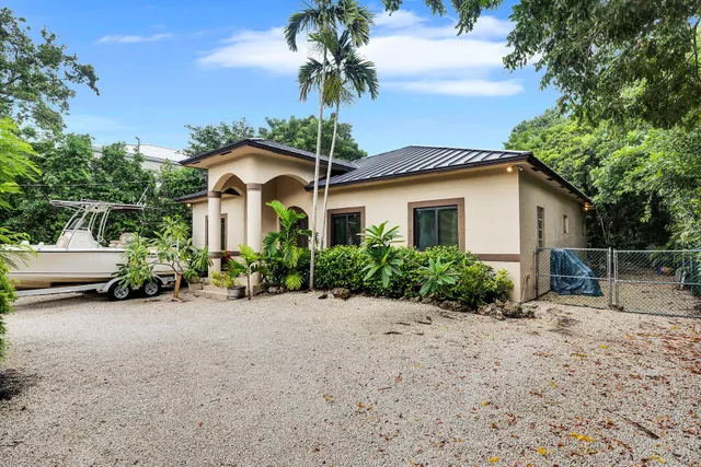 a front view of a house with a yard and potted plants