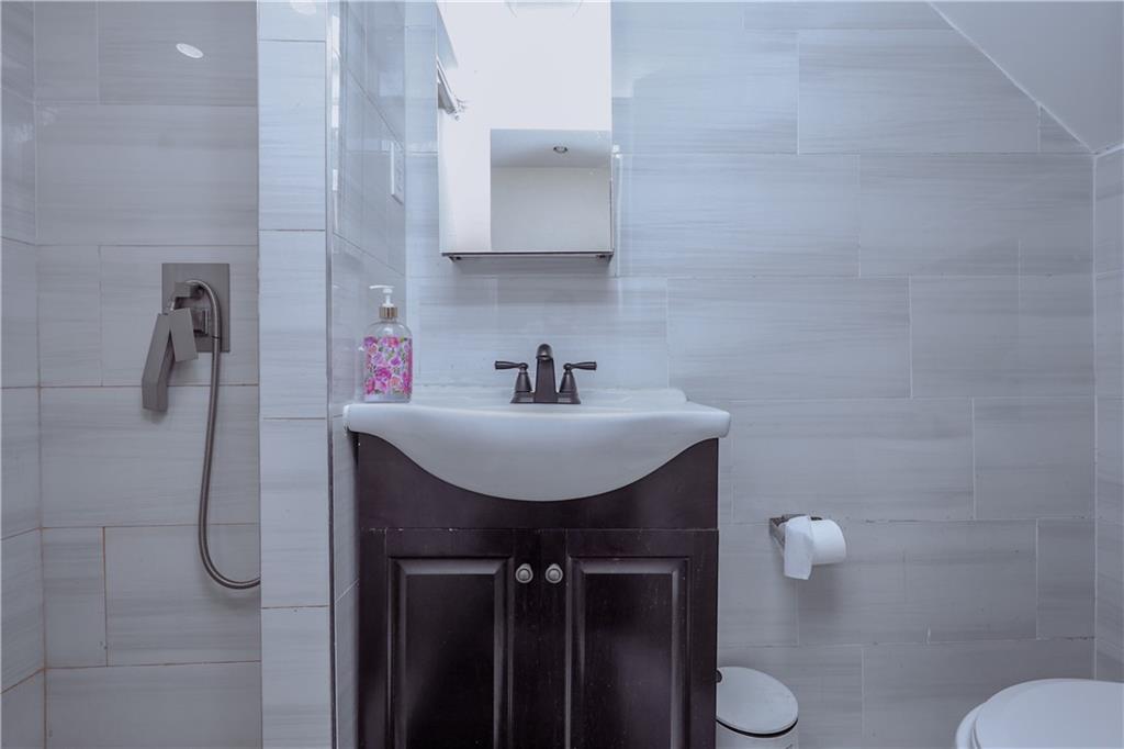 8844 18th Avenue Brooklyn, NY 11214 - Photo 11 of 19 a bathroom with a sink toilet and shower